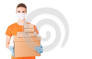 Young girl in a mask and an orange t-shirt holds cardboard boxes for delivery isolated on white background. Donation box