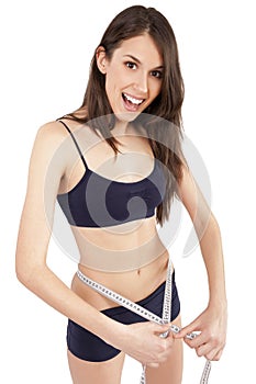 Young girl measuring her waist and being happy