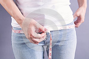 Young girl measuring her waist with a measuring tape