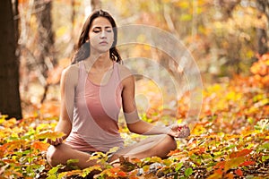 Young girl meditating in autumn park
