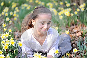 Young girl in the middle of daffodils