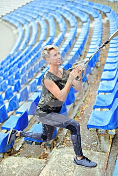 Young girl in the military form doing exercises outdoors