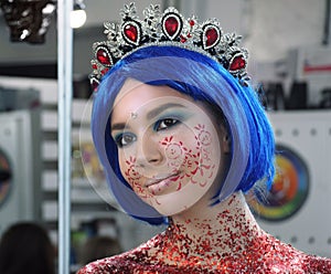 Young girl model in the art make-up like princess in a crown from fairytail happy portrait photo