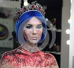 Young girl model in the art make-up like princess in a crown from fairytail looking forward portrait photo