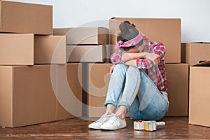 Young girl moving to new place sitting crying exhausted