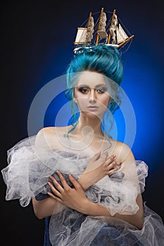 Young girl with naked shoulders and painted blue hair stowed in