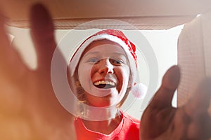 Young girl opening a Christmas present, view from inside of the box