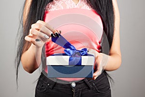 A young girl opens a gift box