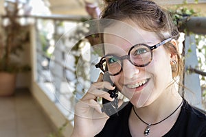 A young girl with orthodontics braces wearing eyeglasses is talk