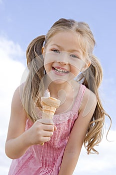 Young girl outdoors eating ice cream cone