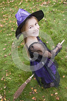 Young girl outdoors in witch costume on Halloween