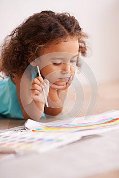 Young girl, painting and brush on floor with paper, creativity and drawing for learning or childhood. Toddler, motor