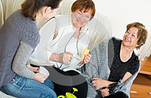 Young girl paying visit to senior grandmothers