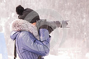 Young girl photographed in the winter in a snow storm on a SLR camera with telephoto lens