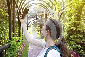 Young girl photographing herself on the phone, on a sunny day