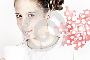 Young girl with a pin wheel and fresh drink