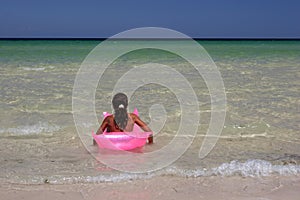 Young girl on pink air-bed in