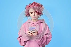 Young girl with pink hair using smartphone