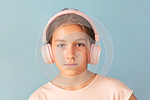 young girl in pink headphones listens to music.