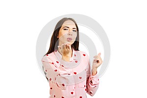 Young girl in a pink shirt with hearts sends an air kiss. Isolated on a white background