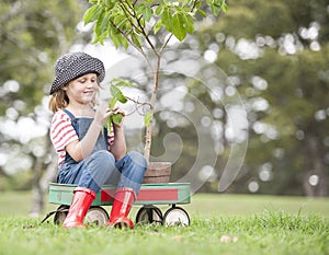 Young girl planting tree in park eco-aware