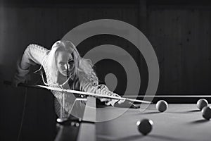 Young girl play billiards black and white