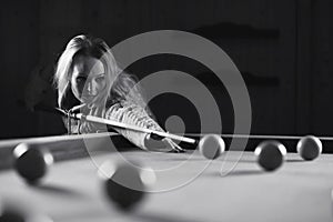 Young girl play billiards black and white