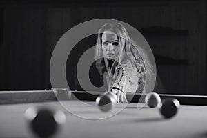 Young girl play billiards black and white