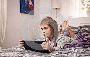 Young girl play on the tablet.