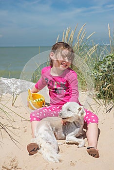 Pretty little girl making sandcastles on the beaches