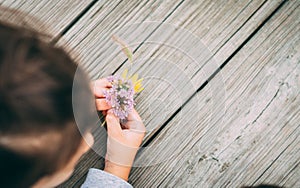 Young girl playing with flowers on the dock