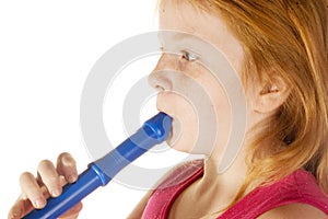 Young girl is playing on a flute