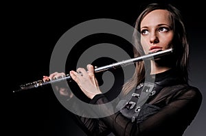 A young girl playing the flute