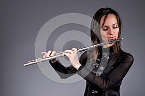 A young girl playing the flute