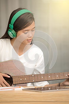 Young girl playing guitar and compose music