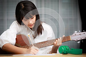 Young girl playing guitar and compose music