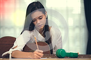 Young girl playing guitar and compose music