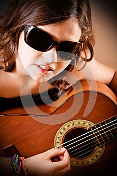 Young girl playing guitar, portrait
