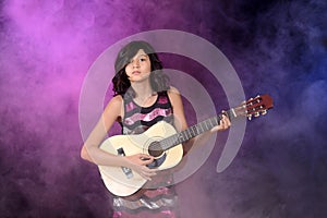 Young girl playing guitar on stage