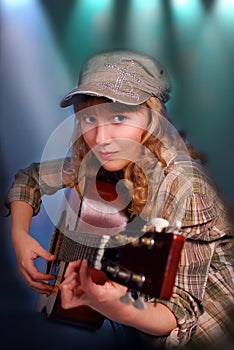 Young girl playing guitar on the stage