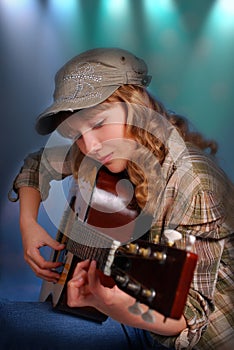 Young girl playing guitar on the stage