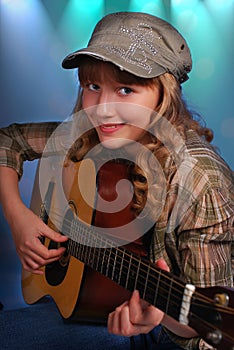 Young girl playing guitar on the stage