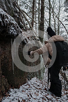 A young girl playing with the icicles during a hike in the winter forest