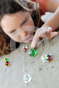 Young girl playing marbles photo