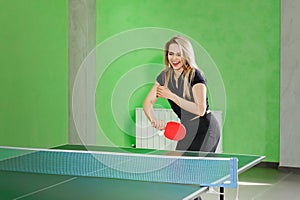 Young girl playing ping pong. athlete kicks the ball with a tennis racket
