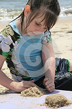 Young girl playing in the sand