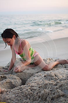 Young girl playing in sand on the beach