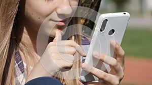 Young Girl Playing Smartphone, Adolescent Kid Browsing Internet on Smart Phone in Park, Teenager Child use Devices Outdoor Nature