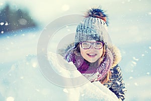 Young girl are playing with snow.Beauty Winter happy Girl Blowing Snow in frosty winter park or outdoors. Girl and winter cold we