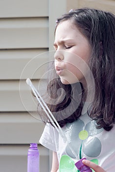 young girl playing with soap bubbles